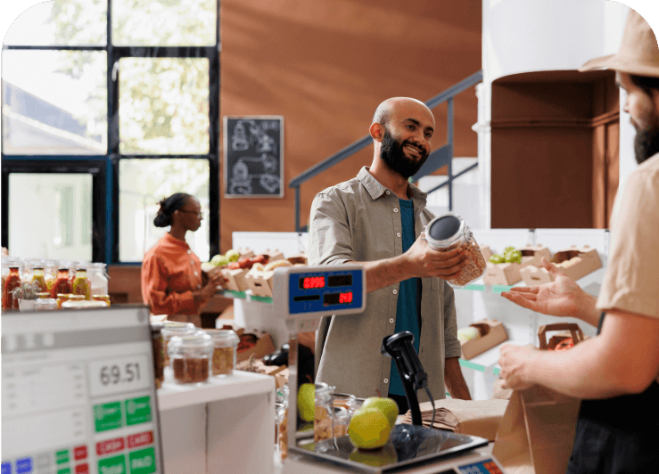A customer and vendor interacting by the vendor's counter